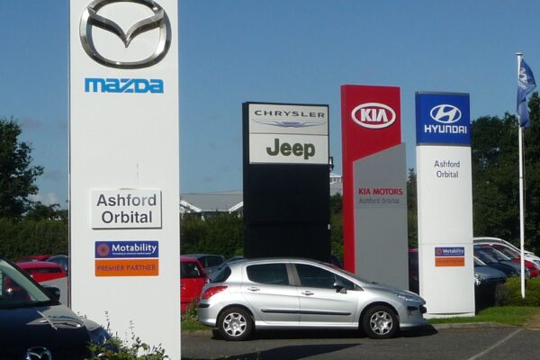 Row of new cars for sale at a dealership lot